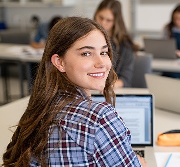 Teen girl smiling while working in classroom