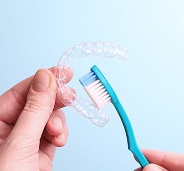 Patient cleaning clear aligner with toothbrush