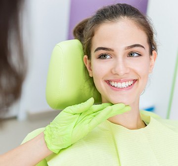 Orthodontist looking at teen's straight teeth