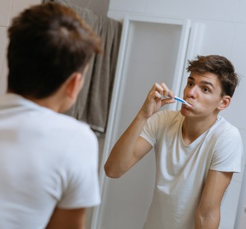 Teenage boy brushing his teeth in bathroom