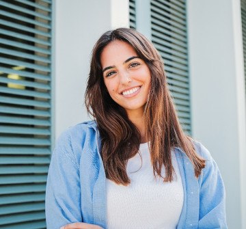 Woman with white teeth smiling while standing outside