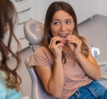 Smiling teenager putting on clear aligner