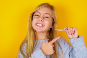 a young patient admiring their Invisalign aligner